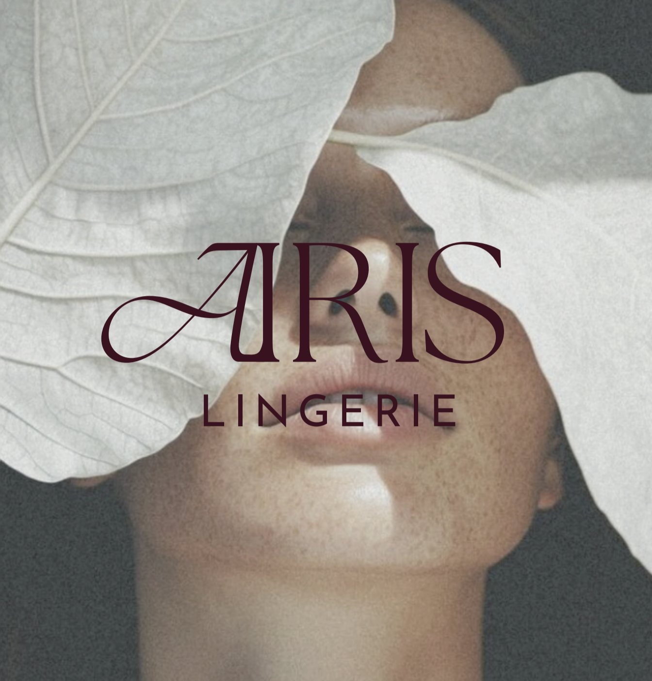 A woman's face, partly covered by two pale leaves, with the Airis Lingerie logo across it